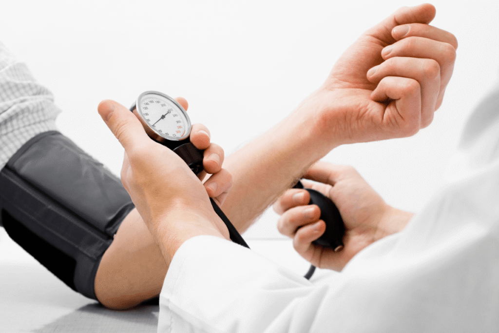 Doctor checking patient blood pressure using manual sphygmomanometer for hypertension diagnosis